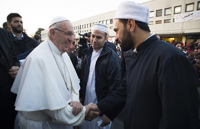 Pope Francis shakes hands with Muslim faithfuls during his visit at the Castelnuovo di Porto refugees center, some 30km from Rome