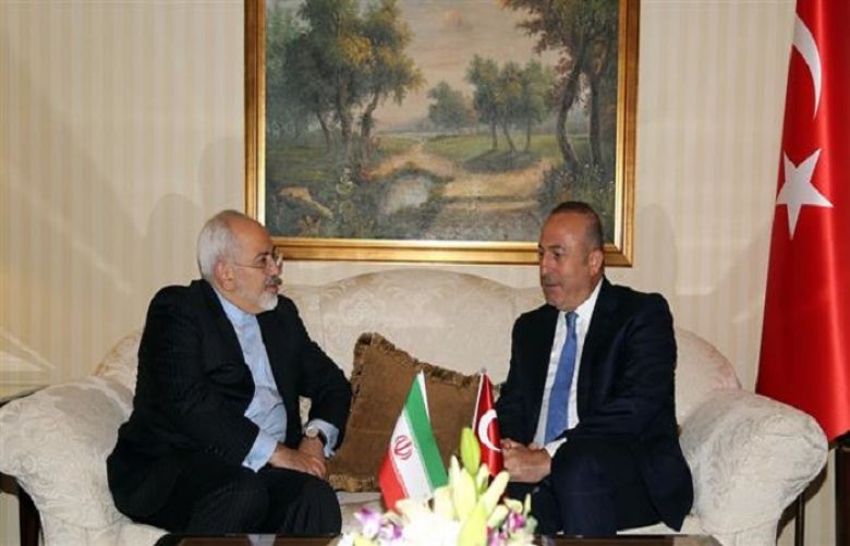 Iran’s Foreign Minister Mohammad Javad Zarif (L) and his Turkish counterpart Mevlut Cavusoglu meet in Kuwait City on May 26, 2015