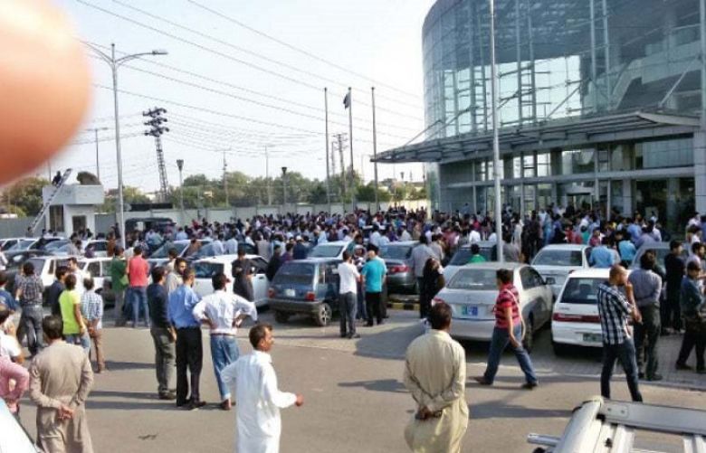 Panic-stricken people stand in the parking lot of the Arfa Software Technology Park.