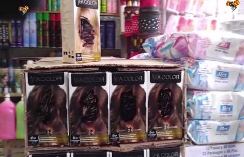 A still from the video shows the blackened faces of models on hair dye products.