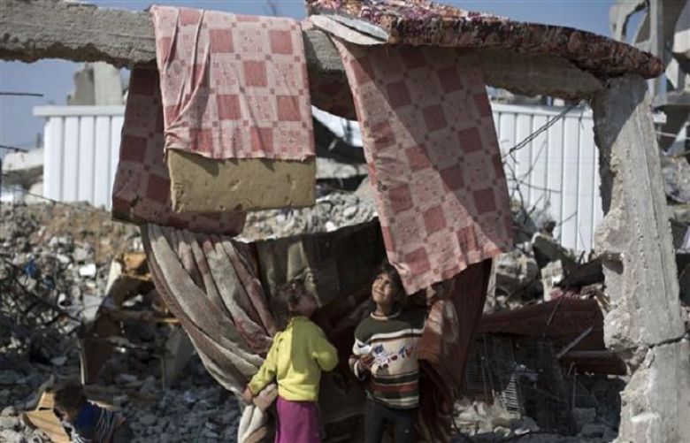 The photo dated March 13, 2015 shows Palestinian children playing amidst debris of houses that were destroyed during last year&#039;s 50-day Israeli war, in the Gaza Strip town of Beit Hanun.