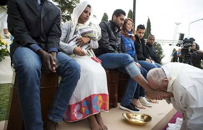Pope Francis kisses the foot of a refugee during the foot-washing ritual at the Castelnuovo di Porto refugees center near Rome, Italy, March 24, 2016.