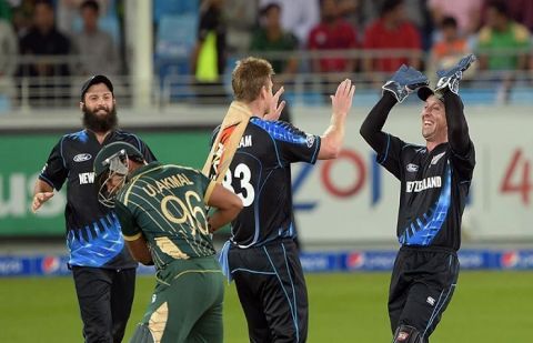 New Zealand bowler James Neesham (2R) celebrates with wicketkeeper Luke Ronchi (R) and teammate Anton Devcich (L) after taking the wicket of Pakistani batsman Umar Akmal (2L) during the second and last International T20 cricket match at Dubai.