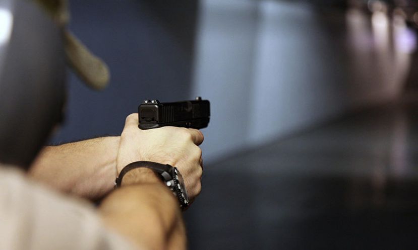 A man fires a hand gun at Sandy Springs Gun Club and Range, in Sandy Springs, Ga.
