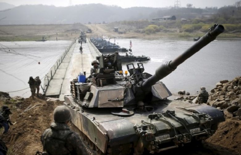 A U.S. army M1A2 tank crosses a pontoon bridge.