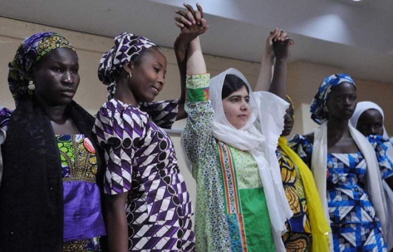 Malala Yousafzai raises her hands with some of the escaped kidnapped school girls of government secondary school Chibok during a news conference in Abuja, Nigeria on July 14, 2014.