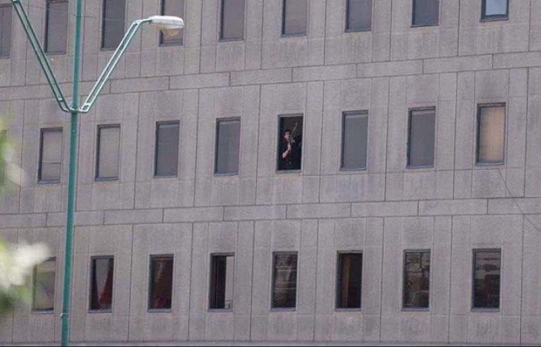 Picture shows one of the purported gunmen trapped inside as  Iran Parliament Building is under siege by security forces