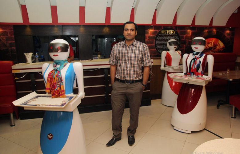 Pakistani engineer Osama Jafari (C) poses with robot waitresses Annie (L), Rabia (R) and Jennie (background) at his pizza restaurant in Multan.