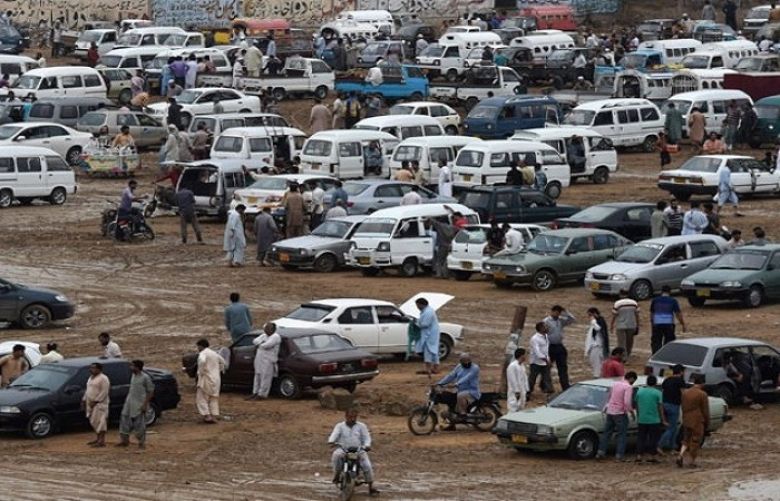 In this photograph taken on July 26, 2015, people gather around cars at the Sunday car market in Karachi.