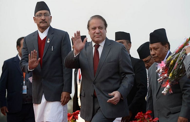 Prime Minister Muhammad Nawaz Sharif (C) waves on his arrival at Tribhuvan International Airport to attend the 18th South Asian Association for Regional Cooperation (SAARC) summit in Kathmandu on November 25, 2014.