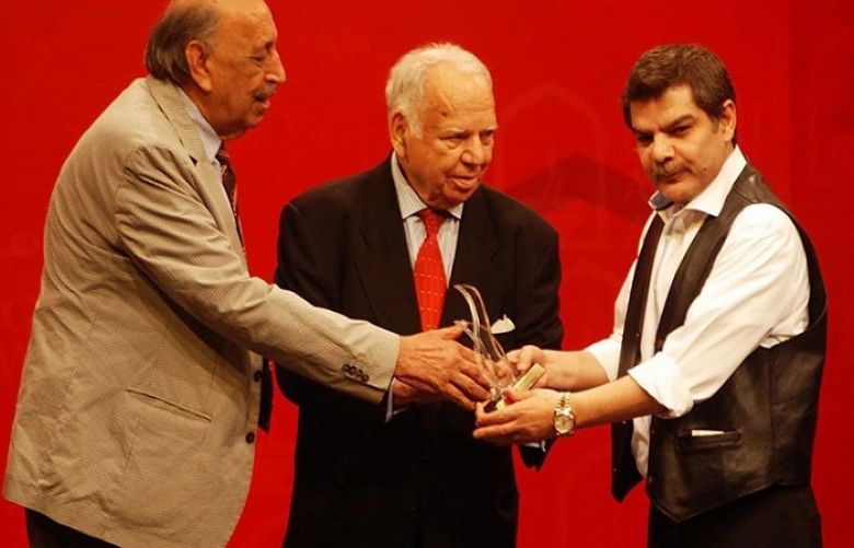 Former Senator Akram Zaki giving Agahi Award to Mubashir Luqman