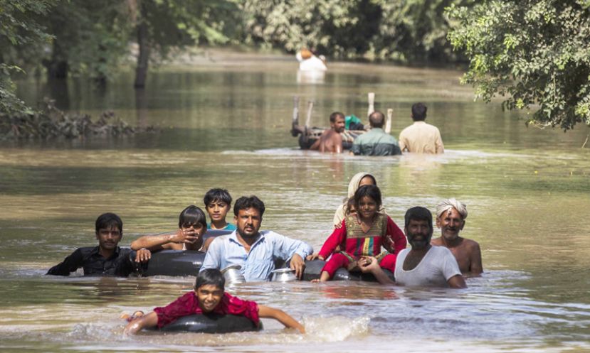 Flood victims wade through a flooded area along a road as they wait for help, in Multan, Punjab province September 13, 2014.