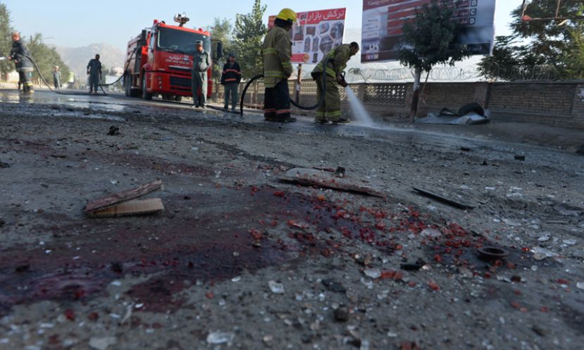 Afghan firefighters wash a road at the site of a suicide attack in Kabul. 