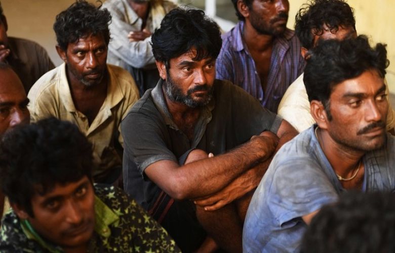Arrested Indian fishermen sit in a police station in Karachi.