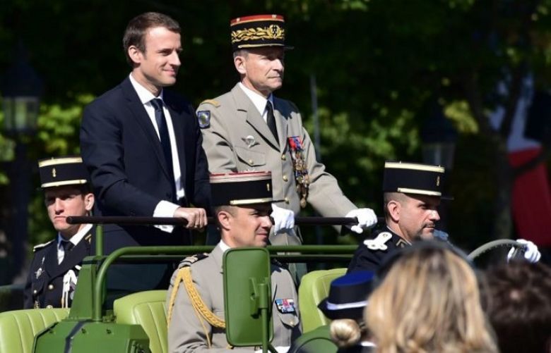 French President Emmanuel Macron (L) and Chief of the Defence Staff, French Army General Pierre de Villiers ride aboard a command car during the annual Bastille Day military parade on the Champs-Elysees avenue in Paris on July 14, 2017