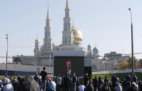 People listen to Russian President Putin, who delivers a speech at a ceremony to open the Moscow Grand Mosque in Moscow.