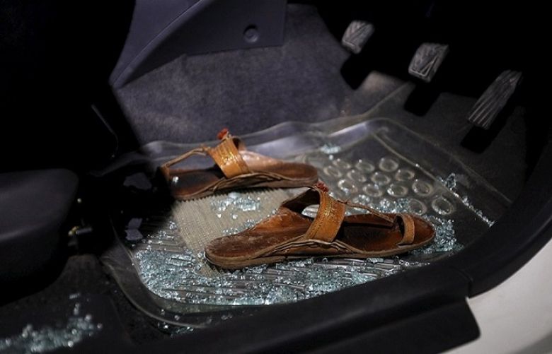 A pair of sandals lies amid broken glass in a car after the attack