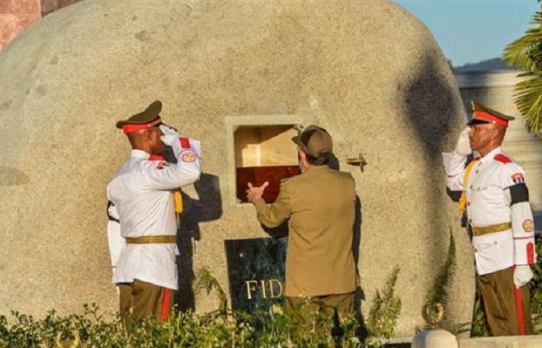 Cuba&#039;s President Raul Castro (C) places the box containing the ashes of Cuba’s former President Fidel Castro into a boulder at the Santa Ifigenia Cemetery, in Santiago de Cuba,
