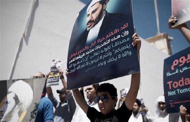A young Bahraini protester holds a placard portraying Sheikh Ali Salman, on April 3, 2015, during a demonstration against his arrest, in the village of Diraz, west of Manama.