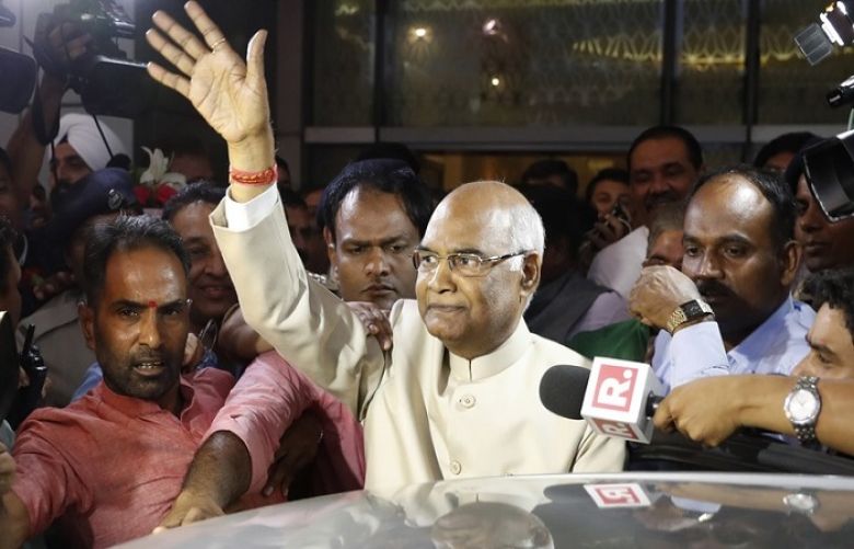 Ram Nath Kovind, center, waves to media upon arrival at the airport in New Delhi, India on June 19