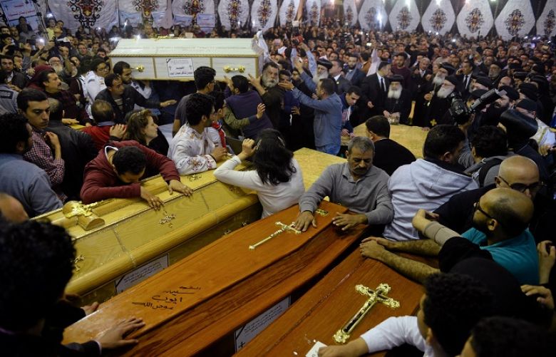 People watch as the coffins of victims arrive to the Coptic church that was bombed on Sunday, in Tanta, Egypt, April 9, 2017.