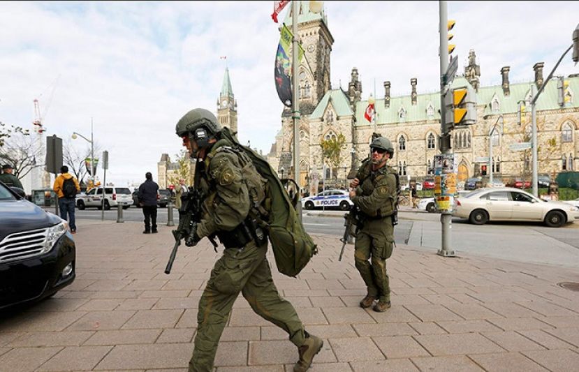 Armed RCMP officers head towards the Langevin Block on Parliament Hilll following a shooting incident in Ottawa October 22, 2014.