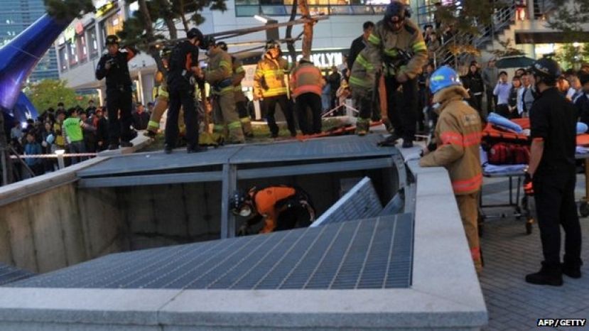 Rescue workers examine the broken ventilation grate which collapsed during Friday&#039;s concert