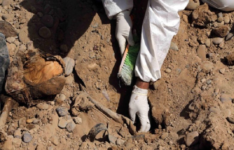An Iraqi forensic worker excavates human remains in a mass grave, believed to contain the bodies of Iraqi soldiers killed by ISIS militants when they overran.