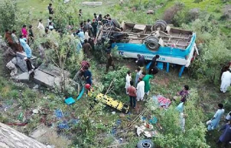 People gather around the bus after it plunged into a ravine near Murree.