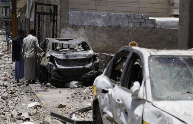Men look at a car destroyed by a recent Saudi airstrike in Yemen&#039;s capital, Sana&#039;a, Saturday, April 25, 2015.