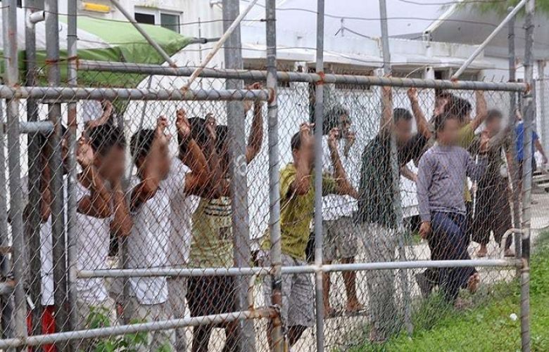 Asylum-seekers look through a fence at the Manus Island detention centre in Papua New Guinea.