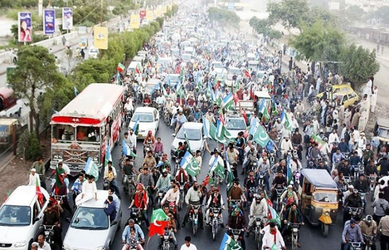 Supporters of PTI and JI pass through a road during election campaign rally in Karachi. 