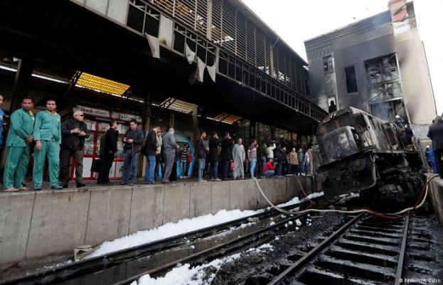 Security forces and onlookers gather at the scene of a fiery train crash at the Egyptian capital Cairo's main Ramses railway station on February 27, 2019