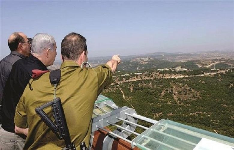 Israeli Prime Minister Binyamin Netanyahu (C) is seen viewing the Syrian border from a stand overlooking the occupied Golan Heights in Aug. 2015.