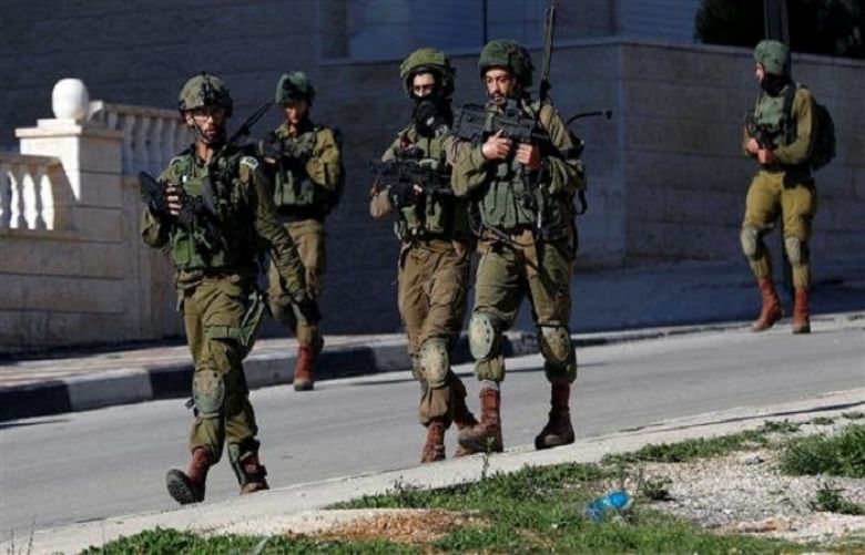 Israeli forces walk during a raid near the city of Ramallah in the occupied West Bank, December 15, 2018. 