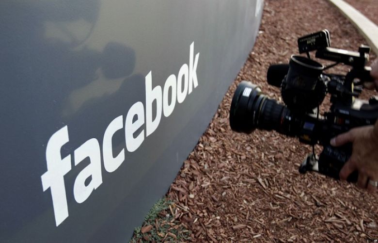 A television photographer shoots the sign outside of Facebook headquarters in Menlo Park, Calif., May 18, 2012.