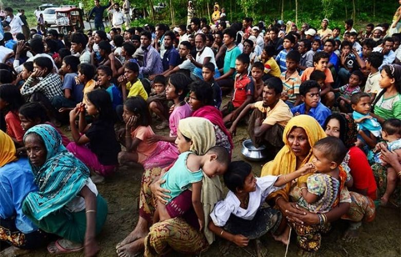 Rohingya people wait for relief supplies near a refugee camp in Kutupalong in the Bangladeshi district of Ukhia.