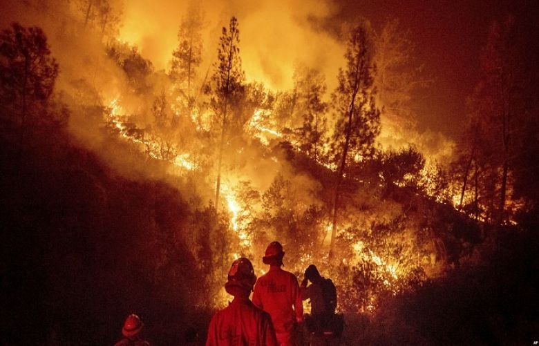 Firefighters monitor a backfire while battling the Ranch Fire, part of the Mendocino Complex Fire near Ladoga, Calif., Aug. 7, 2018.