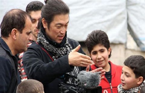 Slain Japanese journalist Kenji Goto speaks with local children in Aleppo, northern Syria.