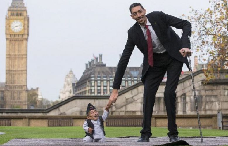 Chandra Bahadur Dangi, from Nepal, (L) the shortest adult to have ever been verified by Guinness World Records, poses for pictures with the world’s tallest man Sultan Kosen from Turkey, during a photocall in London on November 13, 2014, to mark Guinness World Records Day. Chandra Dangi, measures a tiny 21.5in (0.54m) the same height as six stacked cans of beans. Sultan Kosen measures 8 ft 3in (2.51m).