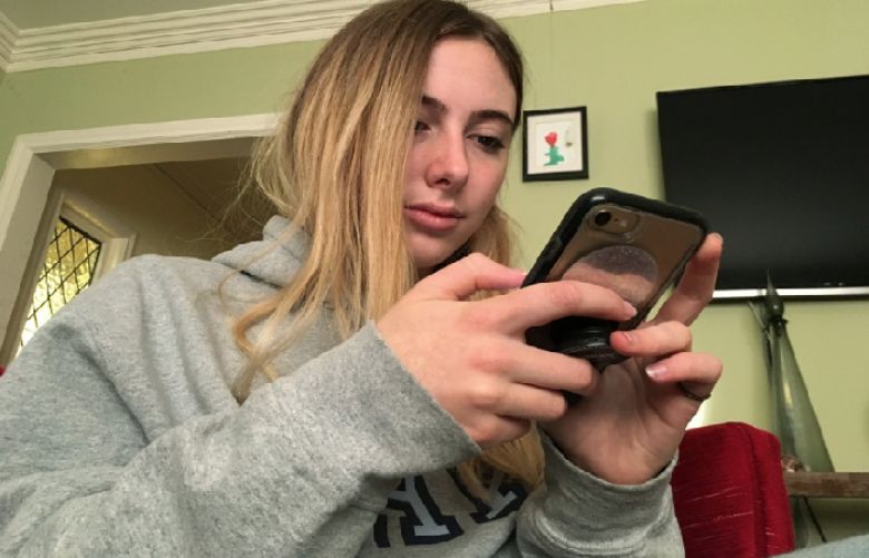 In this Nov. 1, 2018 photo, Laurel Foster holds her phone San Francisco. Foster is among teens involved in Standford University research testing whether smartphones can be used to help detect depression and potential self-harm.