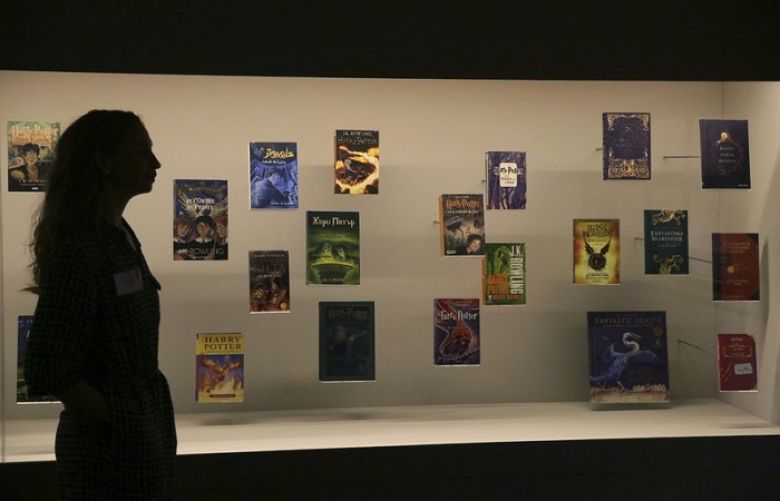 FILE - In this Wednesday Oct. 18, 2017 file photo, a member of British Library staff poses for a picture with Harry Potter books published in several languages at the &quot;Harry Potter - A History of Magic&quot; exhibition at the British Library, in London. Priests at a Catholic parish in northern Poland have burned books, including the “Harry Potter” series, and other items that their owners said had evil forces. Images from the burning at Gdansk’s Mother of Church parish on Sunday March 31, 2019, were posted on Facebook by a Catholic foundation that uses unconventional ways of religious work. 
