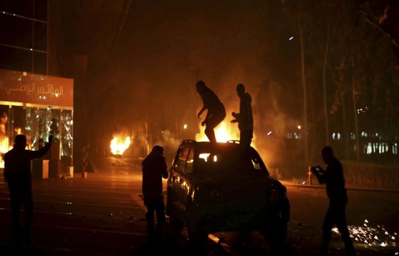 Protesters stand atop a vehicle as others burn in front of the National Conference Hall, in Tripoli, Libya, March 2, 2014, in this image by photographer and video journalist Mohamed Ben Khalifa, who was killed in Libya on Jan. 19, 2019.