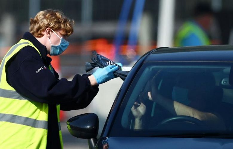 An NHS Track and Trace staff member collects samples at a drive-through test facility following an outbreak of the coronavirus disease (COVID-19) at a car park of Chessington World of Adventures