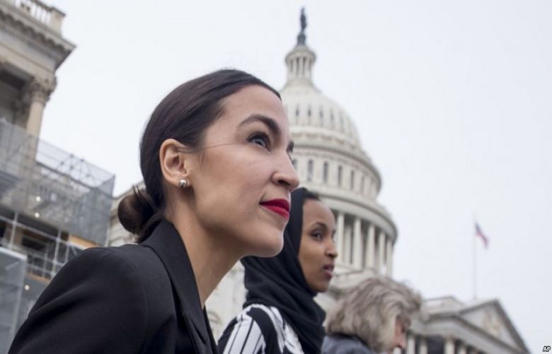 Rep. Alexandria Ocasio-Cortez, left, and D-N.Y., Rep. Ilhan Omar, D-Minn., center, walk down the House steps to take a group photograph of the House Democratic women members of the 116th Congress on the East Front Capitol Plaza on Capitol Hill.