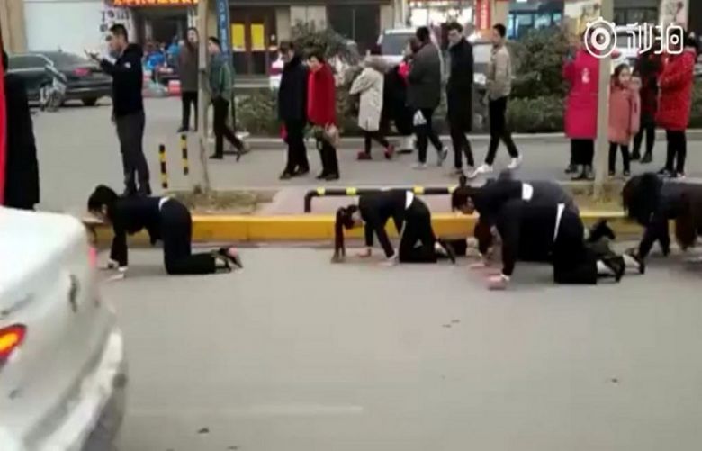 Workers forced to crawl through the street on hands and knees after failing to reach sales targets