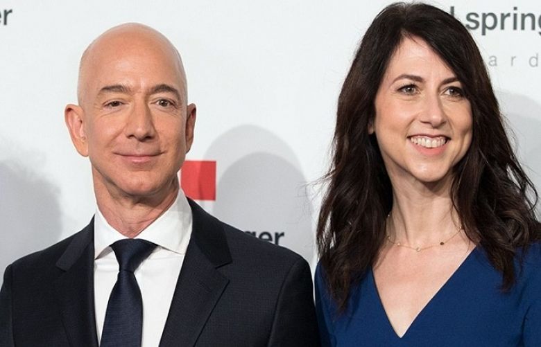 In this file photo taken on April 24, 2018 Amazon CEO Jeff Bezos and his wife MacKenzie Bezos  pose as they arrive at the headquarters of publisher Axel-Springer in Berlin.