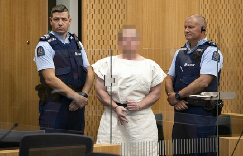 Brenton Tarrant, the man charged in relation to the Christchurch massacre, makes a sign to the camera during his appearance in the Christchurch District Court on March 16, 2019.