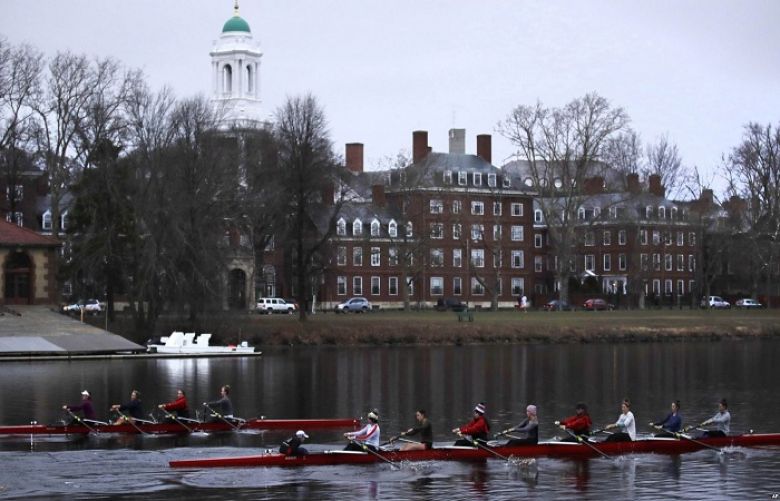 Rowers pass the campus of Harvard University as they move down the Charles River in Cambridge, Mass., March 7, 2017.