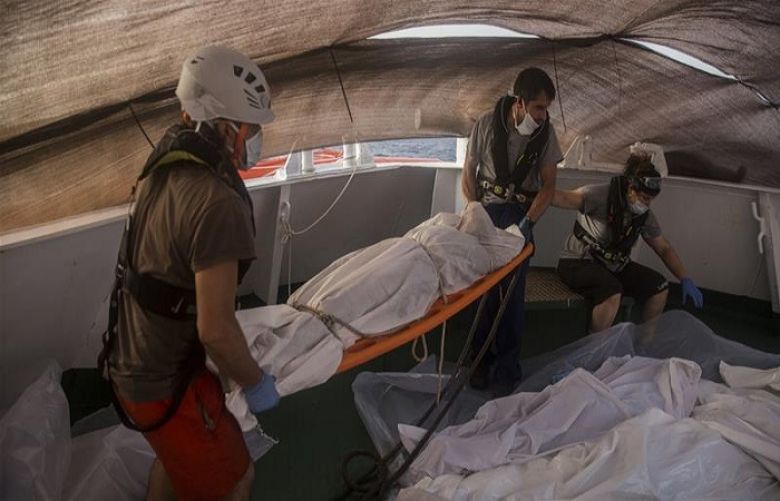 Aid workers recover the bodies of Sub-Saharan migrants in the Mediterranean Sea near Libya